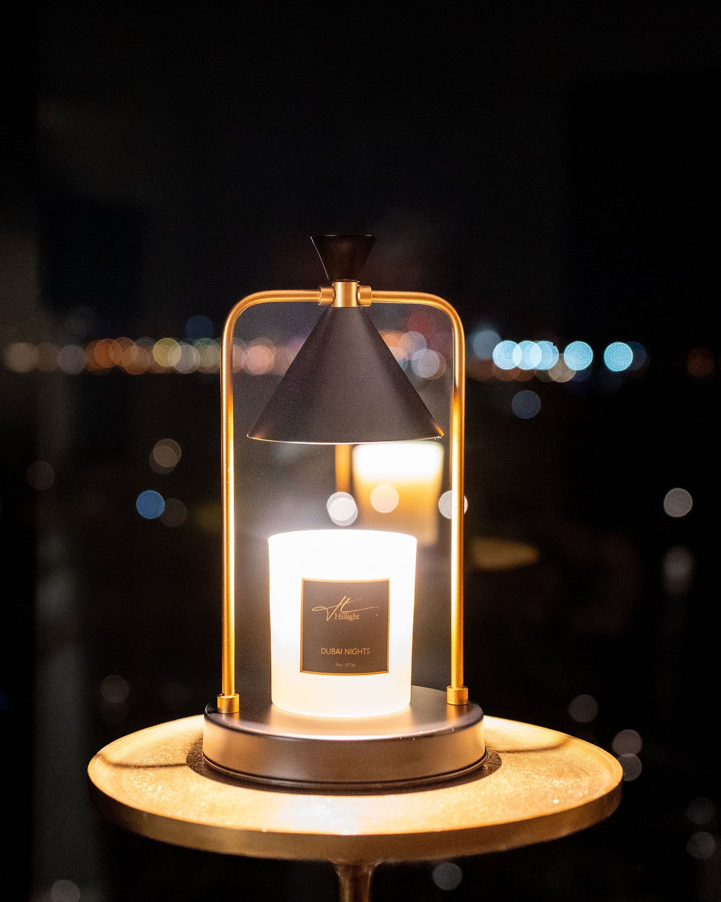 Decorative lantern with a lit candle inside, set against a blurred night-time cityscape.
